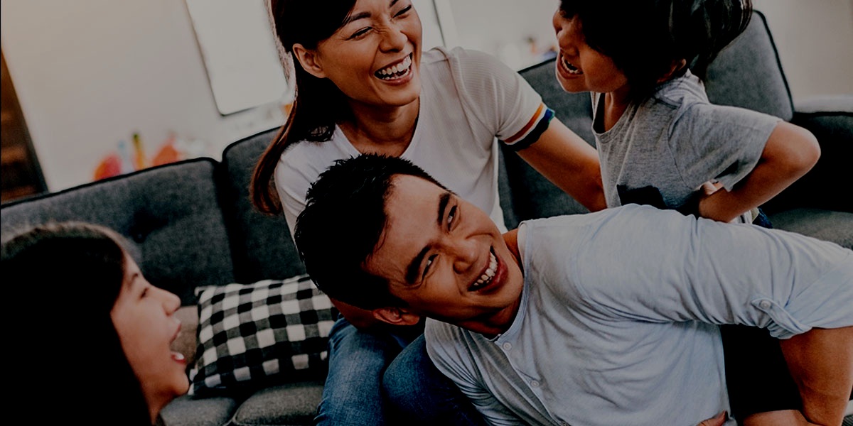 A family laughing together on a couch